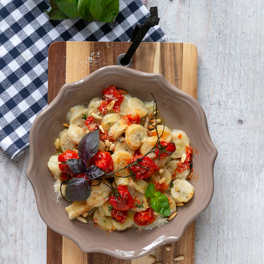 Immagine: Gnocchi di ricotta, pinoli tostati e basilico con pomodorini confit e parmigiano