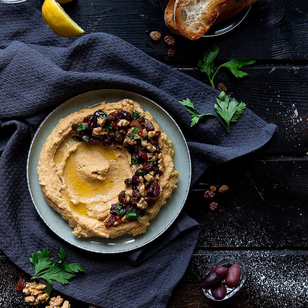 Immagine: Hummus caldo con crunch di noci, uvetta e olive nere Kalamata spadellate