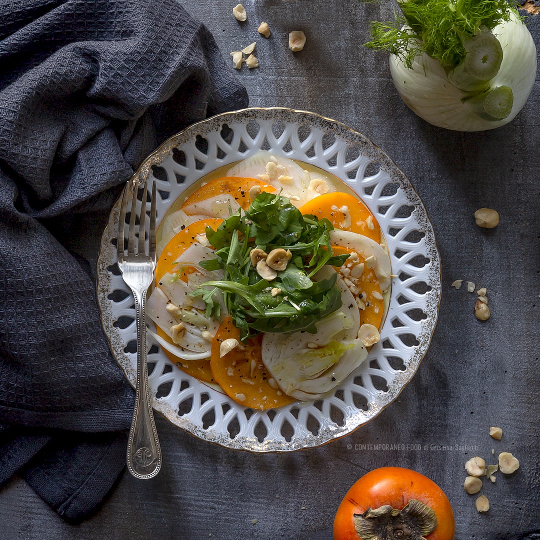 Immagine: Cachi mela in insalata con salsa al miele, finocchi, rucola e nocciole tostate